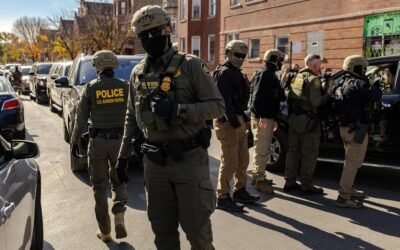 PHOTO: Federal agents confront community members during immigration raids